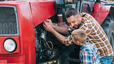 Man and child working on tractor